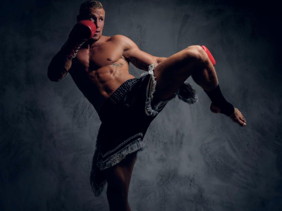A shirtless man in boxing gloves performs a high kick, showing athleticism. Dark, textured background adds intensity to the scene.