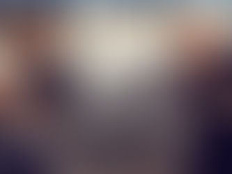 Two people sparring in a gym, wearing boxing gloves and athletic wear. Focused expressions, neutral-toned background.