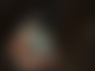 A hand holds an open antique pocket watch with a white face, black numbers, and the word "Quartz." Background is dark and speckled.