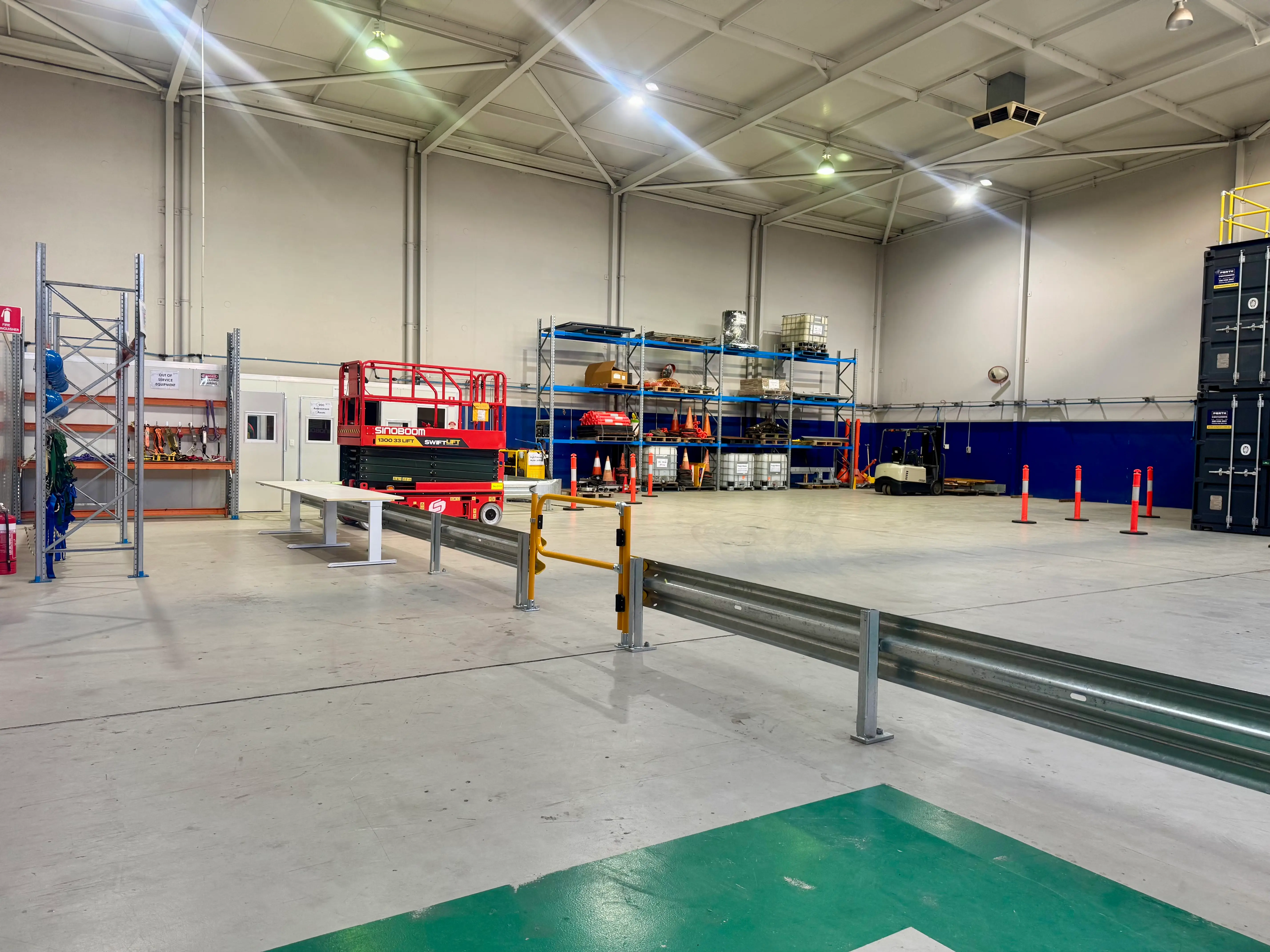 Interior view of the Paratus Training Bayswater facility showing the practical training warehouse, EWP equipment, safety barriers and industrial training area.