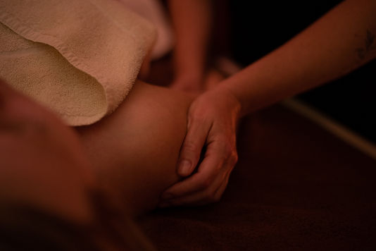 Geste de massage réalisé sur le dos d'une personne dans le cadre d'un soin.