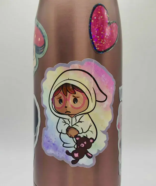 Thumbnail: Sad cartoon creature in a clear onesie holding teddy bear sticker, stuck onto a copper water bottle.