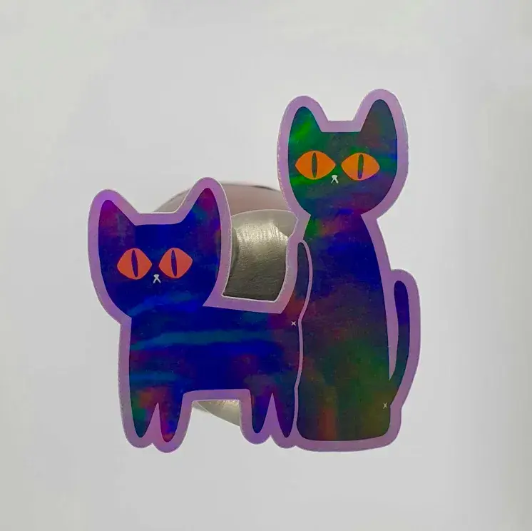 Thumbnail: Two black cats with wide orange eyes, The Watchers - Hand Drawn Holographic Vinyl Sticker, showing holographic finish.