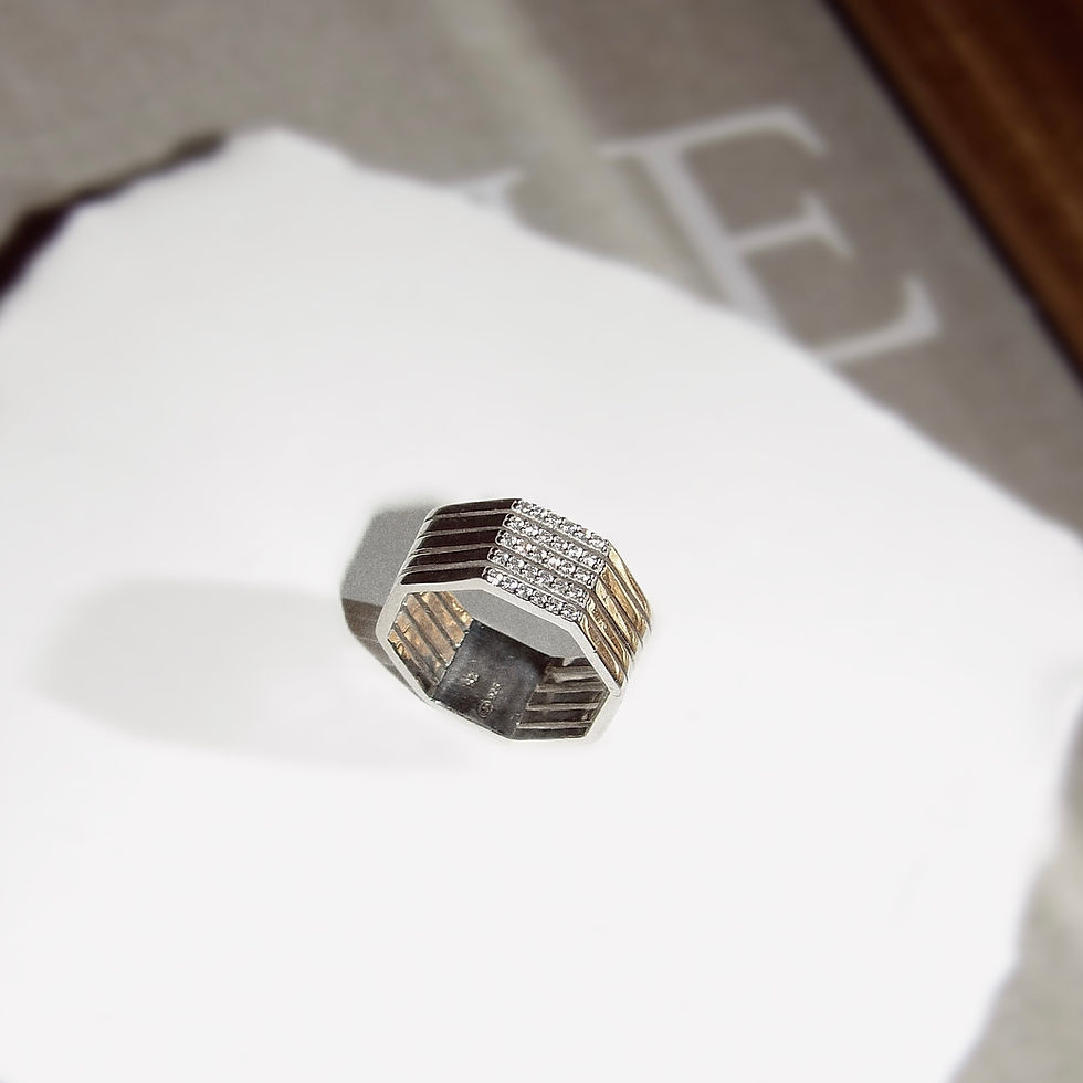 Une bague géométrique argent et or. Bague GABRIELLE sur papier blanc et Macaconcept.