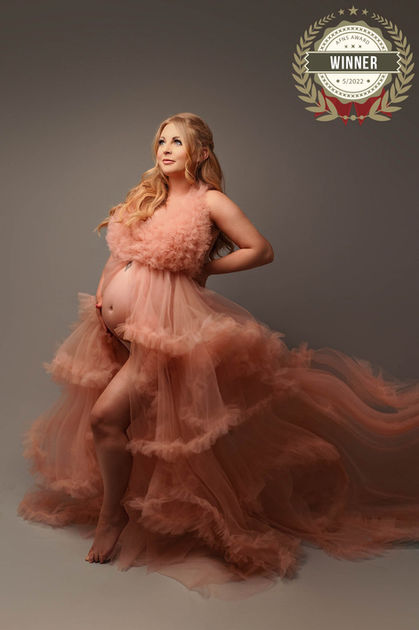 Pregnant woman maternity photo shoot in flowy pink gown dress