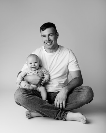 Dad and baby sat on the floor smiling