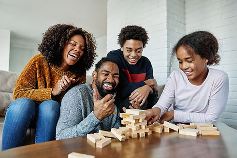 Portrait of a happy african american family at home, having fun playing wooden brick chall