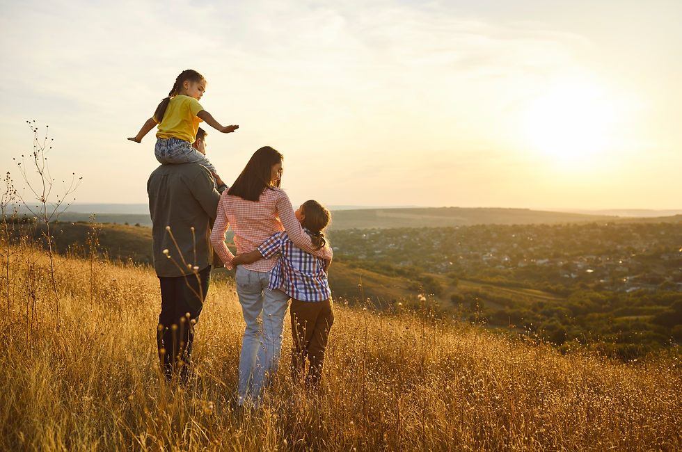 Happy family together at sunset, parents hug children outdoors Golden light warms meadow a