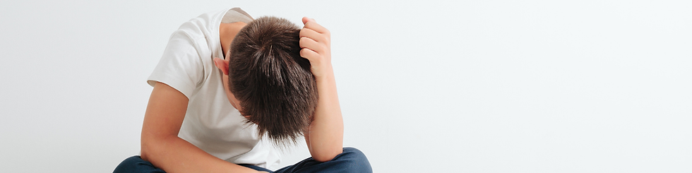 little boy holding his head in his hand