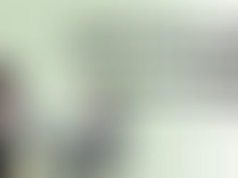 Child and adult sit at a table in a therapy setting. Text reads "SIGNS YOUR CHILD MAY NEED SPEECH THERAPY: School-Age Edition" on a light green background.