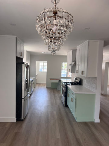 a kitchen with a chandelier hanging from the ceiling