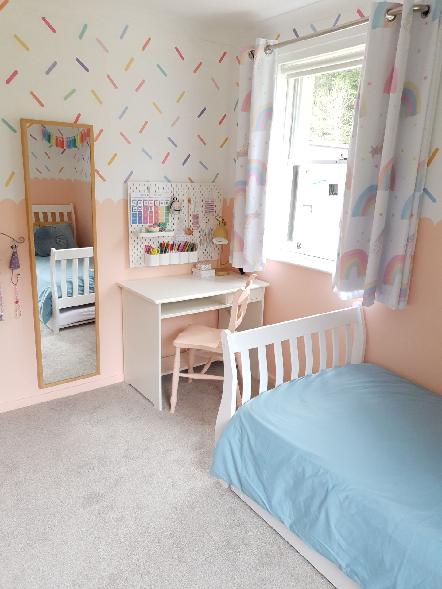 A bedroom with a single bed and desk area in the corner.
