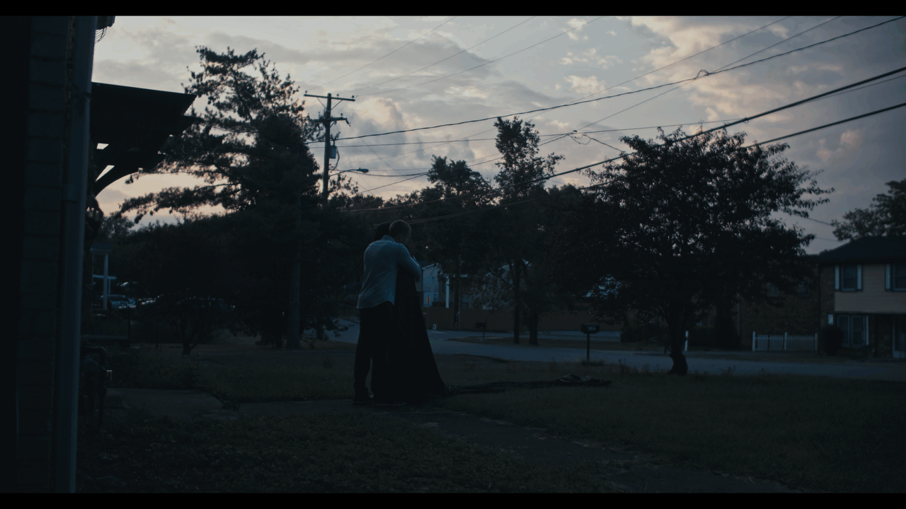 directed by adam settle credit over wide cinematic professional image of two men holding each other outside in a nashville neighborhood with parallax visual effect 