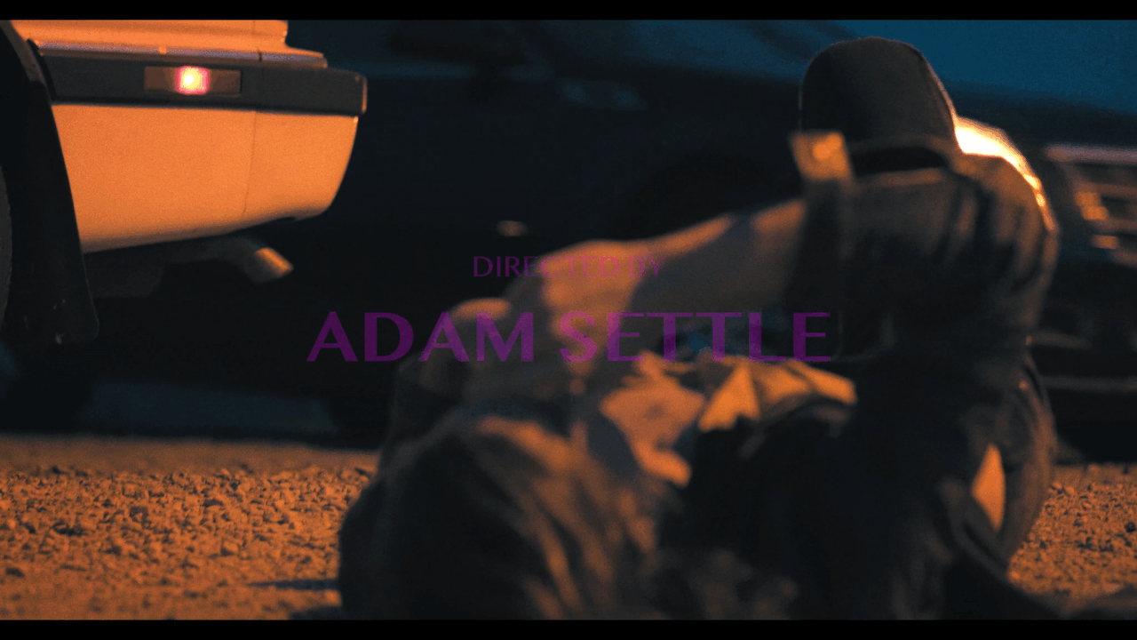 Directed by Adam Settle credit over professionally filmed shot of man lying on the ground as a car drives away behind him in nashville