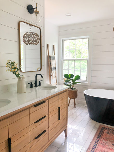 view of teak vanity, black bathtub and light filled bathroom