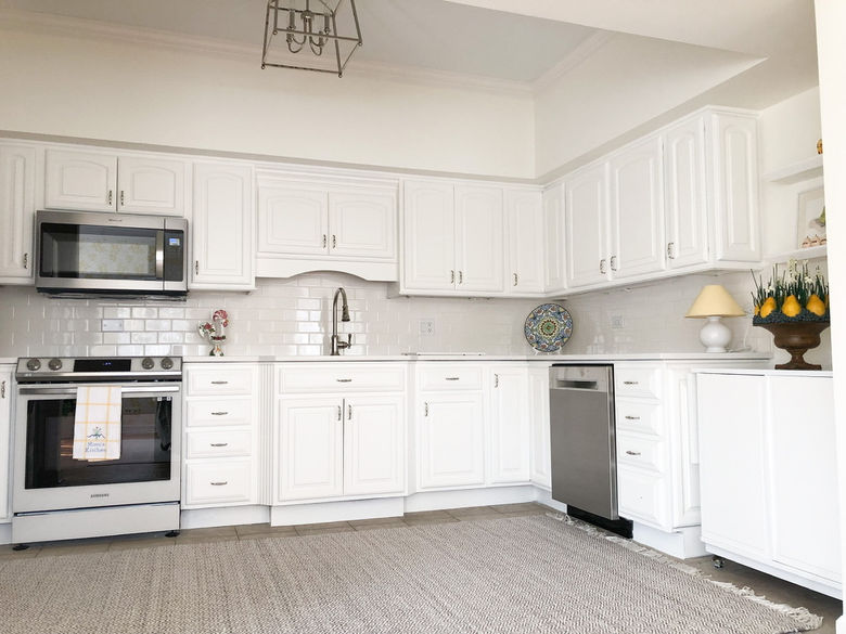 white kitchen cabinets, white stove, white tile