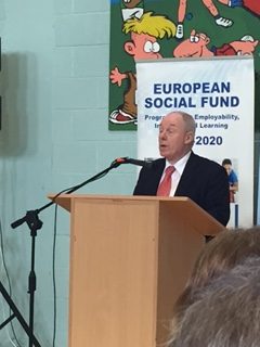 Speaker at podium, European Social Fund banner visible