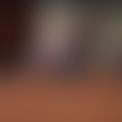 Scott M. Davis, Legislator for the 1st District, speaks into a microphone during a Nassau County Legislative meeting. Seated beside him are Delia DeRiggi-Whitton, Minority Leader of the 11th District, and Carrié Solages, Legislator for the 3rd District. They appear focused and engaged in session.