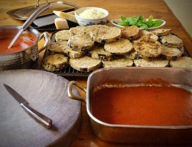 Layering Eggplant and tomato sauce for eggplant parmesan recipe.