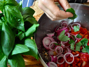 A vibrant bowl of authentic Panzanella salad, featuring crusty bread, ripe red tomatoes, and fresh green basil, perfect for a summer meal.
