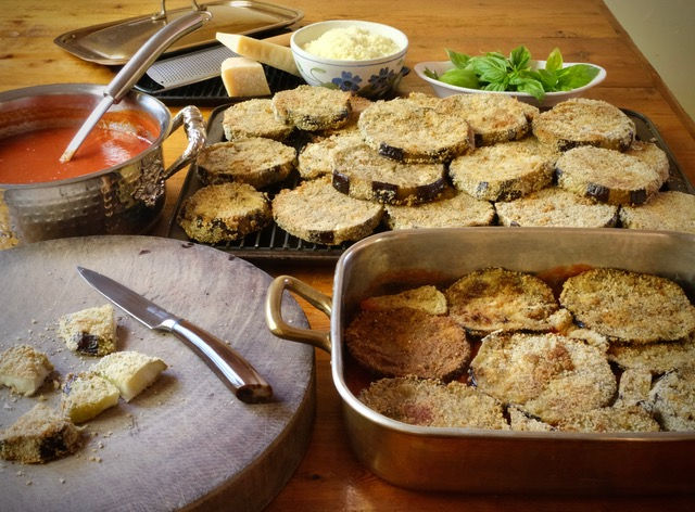 Eggplant parmesan pieces breaded with sauce, parmesan, basil and a dish for eggplant parmesan recipe