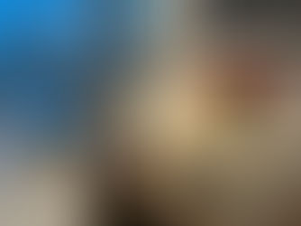 Entryway to a high-rise luxury apartment. The hand crafted Carrara marble lamp provides a soft glow as dusk. On the table a few books with a vase and red tulips. Over the wood table a modern black and white cityscape photo hangs