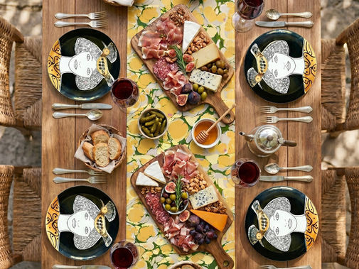 Hand painted ceramic plates on a rustic wood table with Italian linens and charcuterie boards for mothers day brunch
