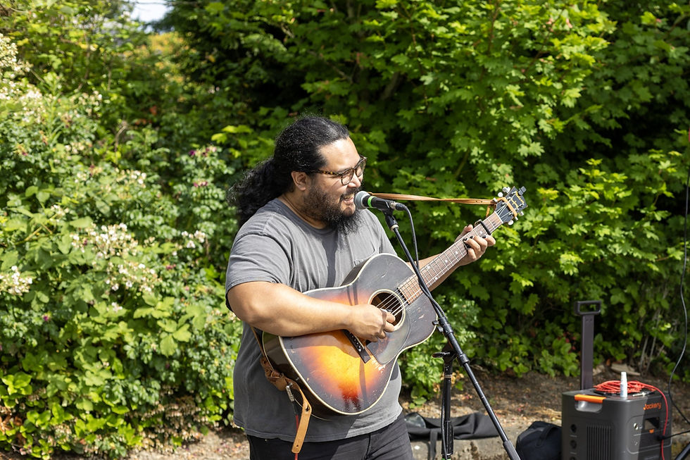 Jed Crisologo, a musician and member of the Structural Leadership Team at the Rhapsody Project, performs songs and stories at the SeaTac Farmers Market.