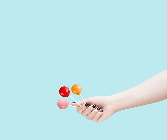 Extended arm and hand holding 3 lollipops