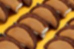 Chocolate-dipped waffle tacos with ice cream on a yellow background. The arrangement forms a pattern, creating a playful, inviting mood.