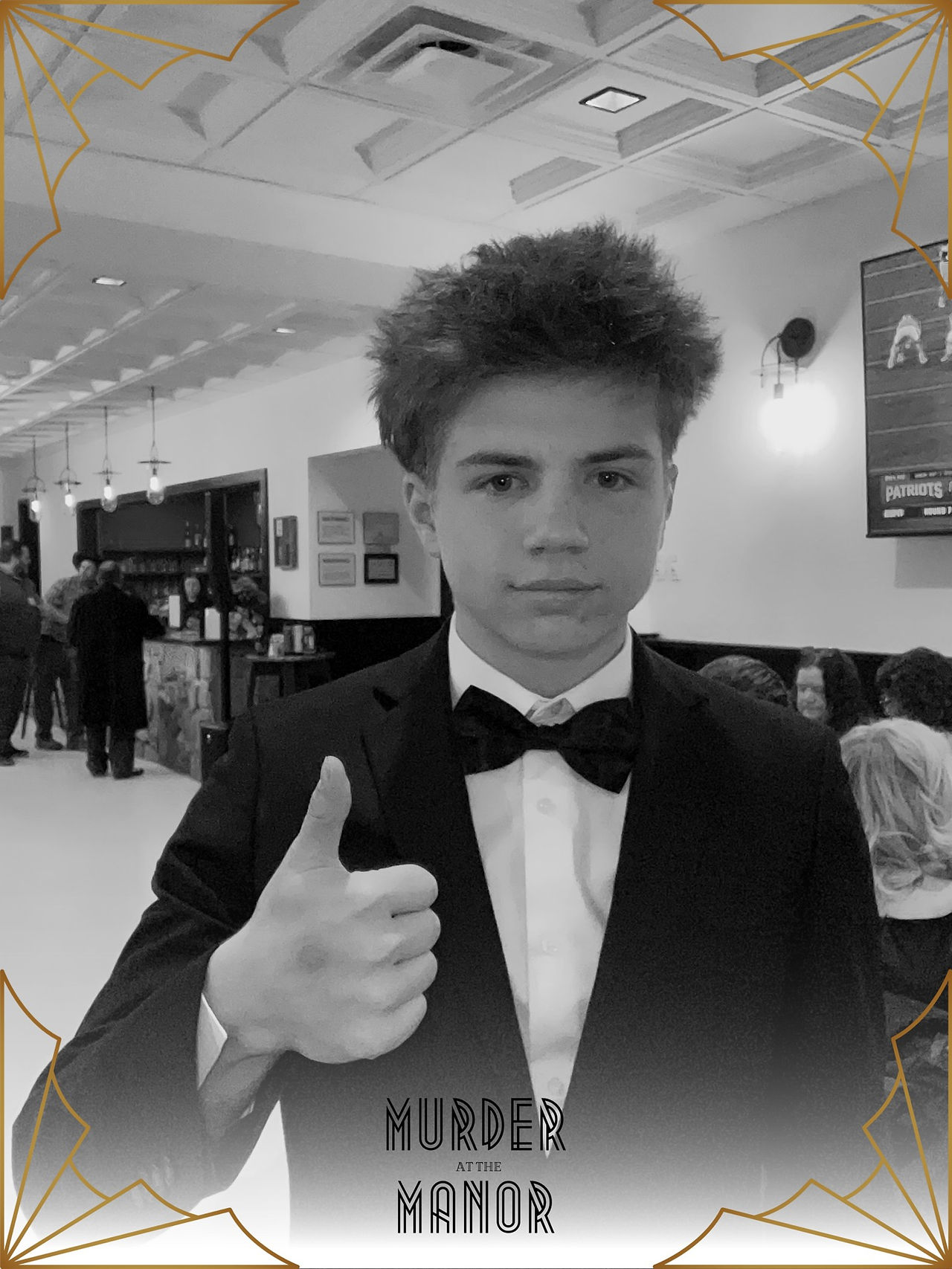 a young man in a tuxedo in black and white, a frame around them reads "Murder at the Manor"