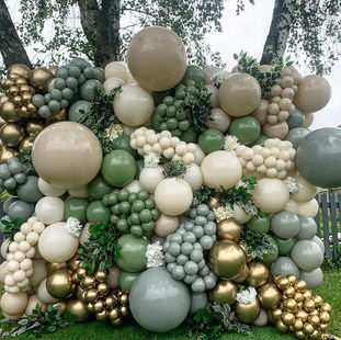 green balloon wall with gold balloons outside 