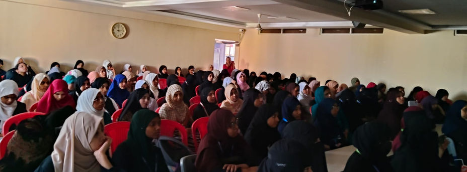 Large classroom filled with students; a lecture is in progress
