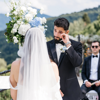 Emotional groom tearing up while exchanging vows with the bride at the wedding altar