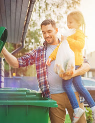 Dad and daughter throwing away trash