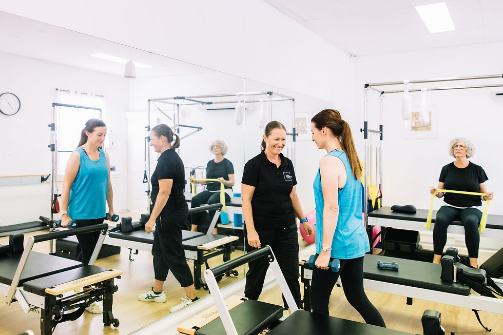 Lady stood with weights and one seated doing guided exercise with physiotherapist