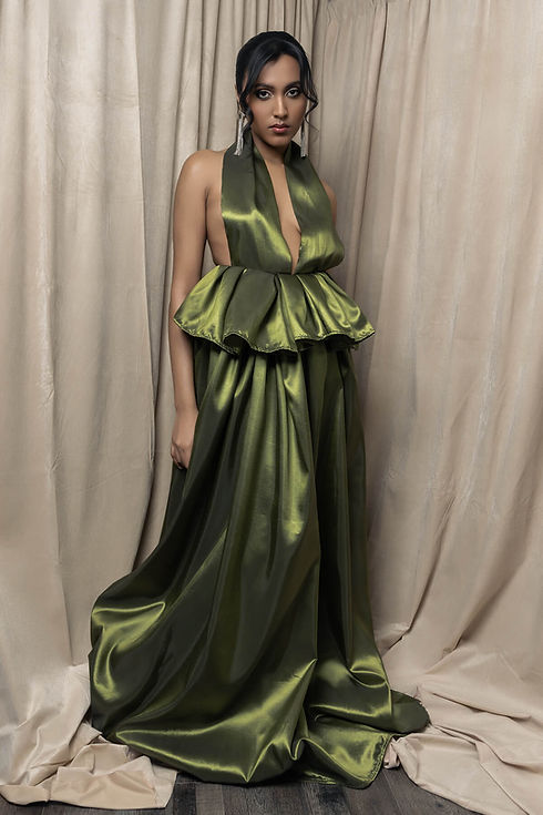 Fine art luxury portrait of woman in green halter draped dress posing against beige backdrop in Brampton photography studio