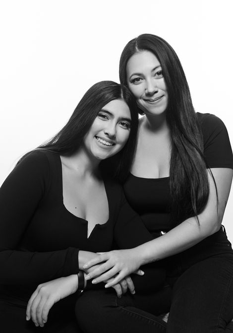 black and white shot of daughter leaning on mother in black clothing posing for mother and daughter fashion shoot