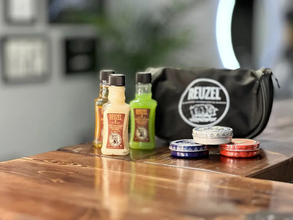 Kolekce produktů Reuzel pro péči o vlasy a vousy v barbershopu The Looks, včetně šamponů a pomád.