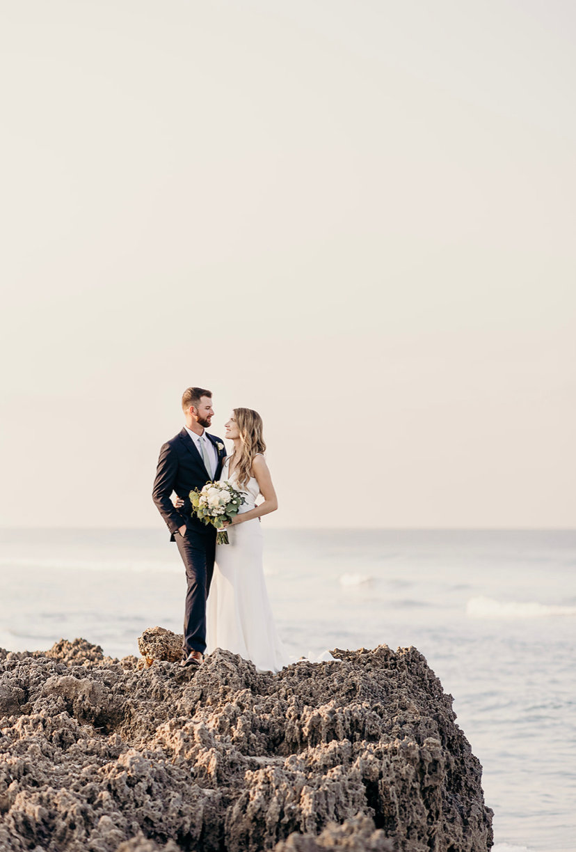 bride and groom on rock ledge.jpeg