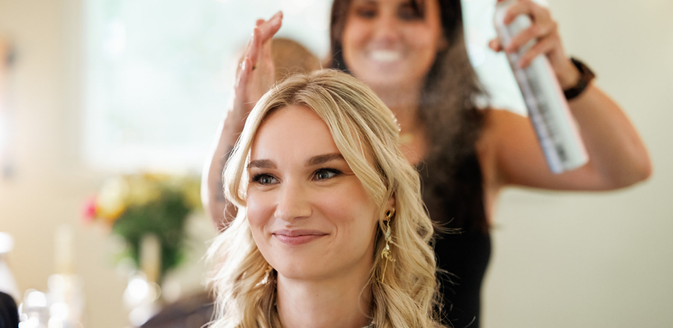 bride getting hair done on wedding day