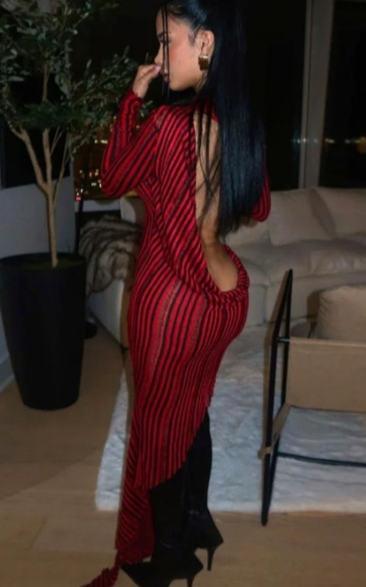 Model wearing the ‘Hot Topic’ evening dress with striped long sleeves and a very low, fully exposed back.