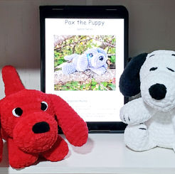 iPad displaying a crochet dog pattern with handmade Clifford and Snoopy plushies beside it