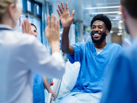 Smiling patient high-fives hospital staff after completing gene therapy for sickle cell disease.