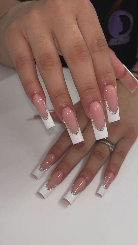Woman's hands with white French tip acrylic nails perfectly manicured