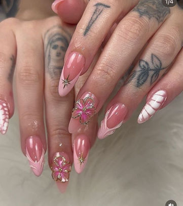 Woman's hands with long acrylic nails artfully designed in pink and white.