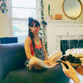 Dana on couch with cakes and candles