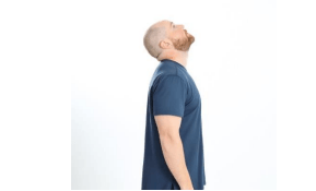 Mike is standing looking up with his neck extended.