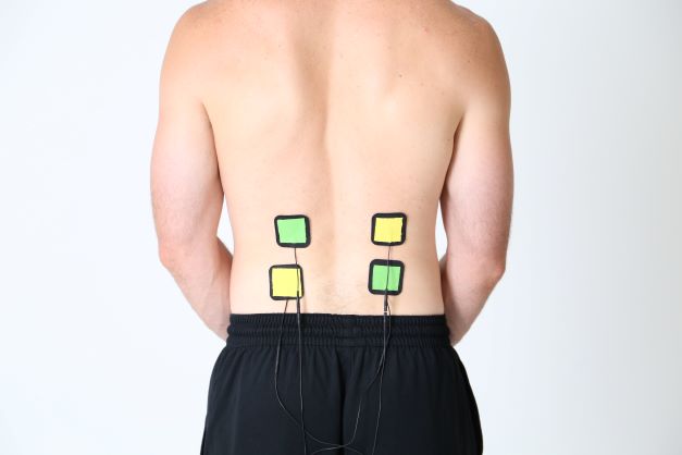 A person using a TENS unit for lower back pain