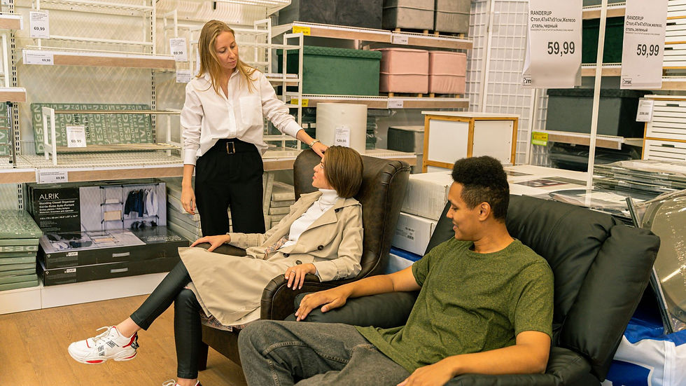 Shopper comparing laptop models with a retail adviser in an electronics store